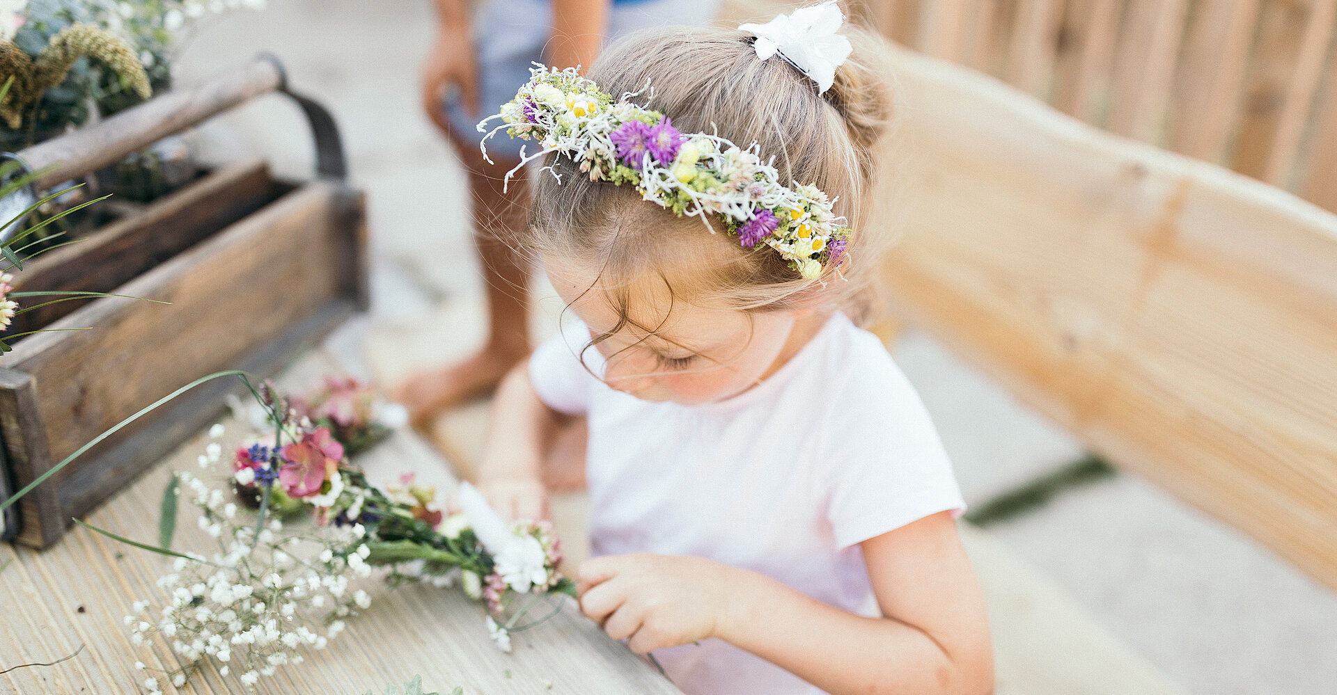 Kinder beim Blumenkranz binden in der Kinderalm im Hotel Unterschwarzachhof