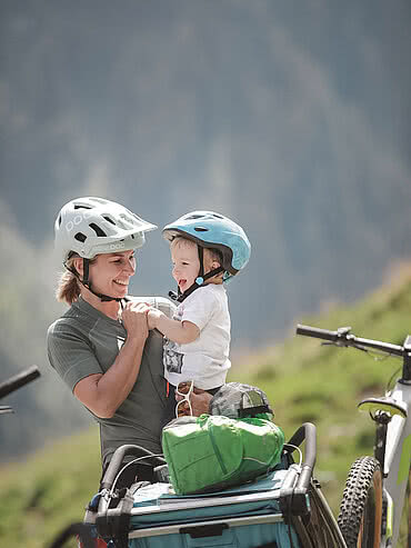 Lady and small child standing next to a bicycle trailer