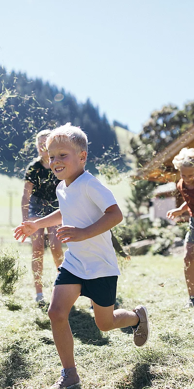 Family & Fun Kinder spielen im Gras beim Hotel Unterschwarzachhof in Saalbach Hinterglemm