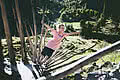 Girl balancing on a tree trunk at the head of the valley in Saalbach Hinterglemm