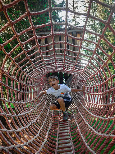 Netztunnel mit Kindern Montelinos Erlebnisweg in Saalbach Hinterglemm